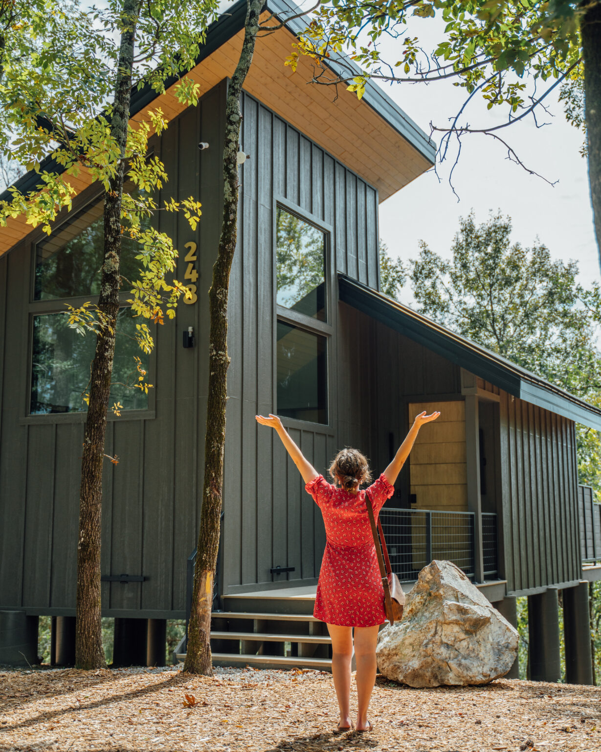 A guest arriving at a cabin, arms raised
